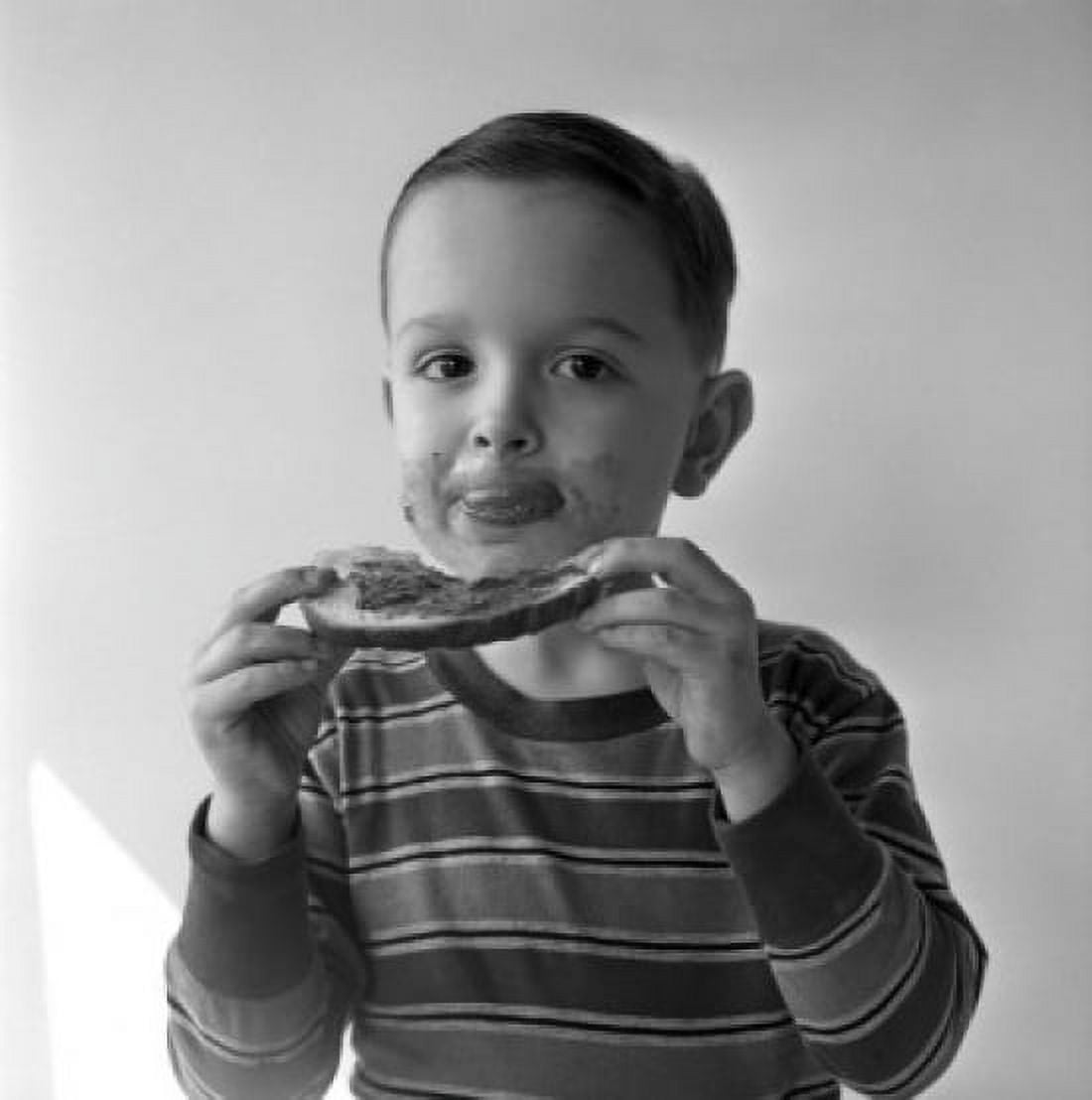Boy eating chunk of bread with peanut butter Canvas Art - (18 x 24)