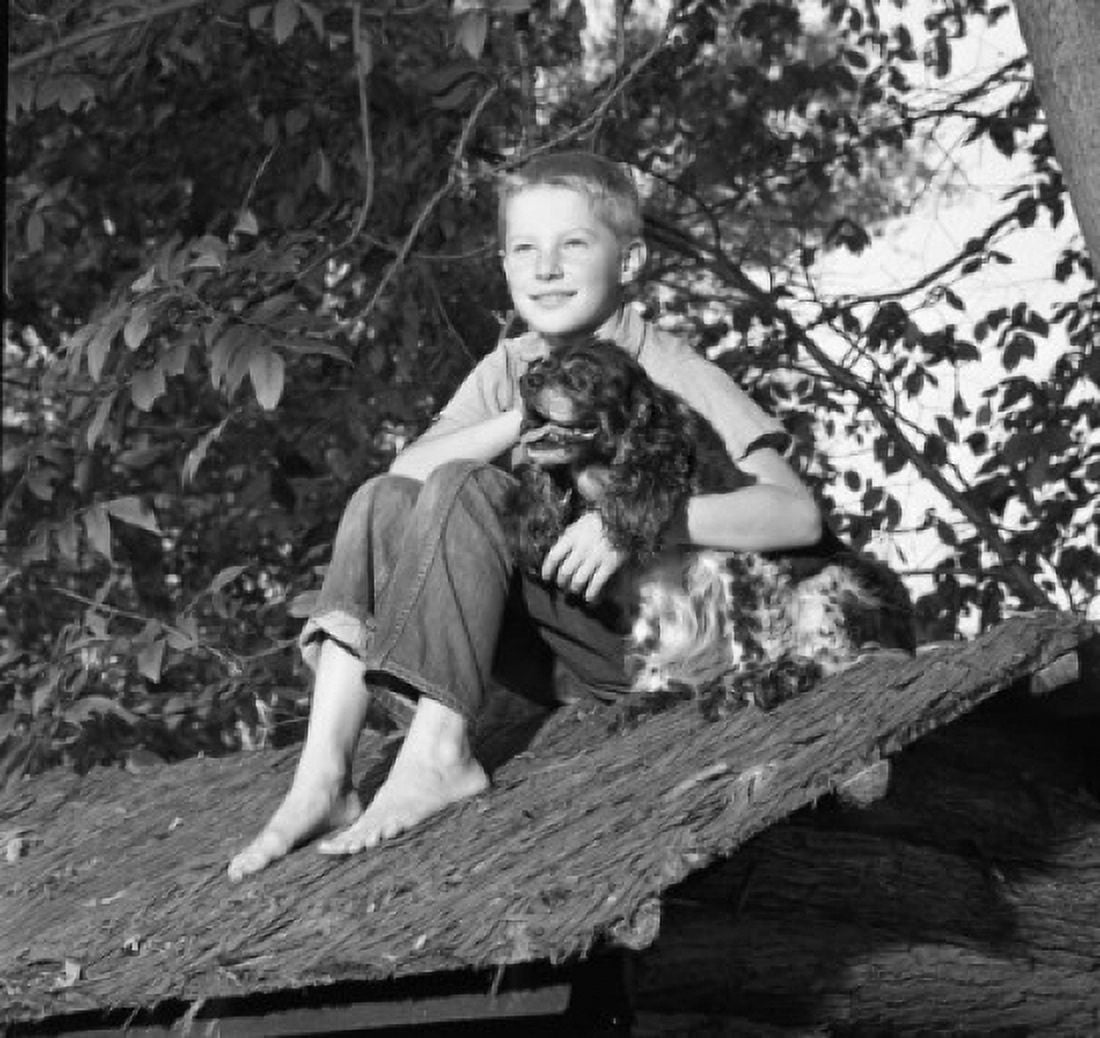 Boy embracing dog on shed roof Canvas Art - (24 x 36)