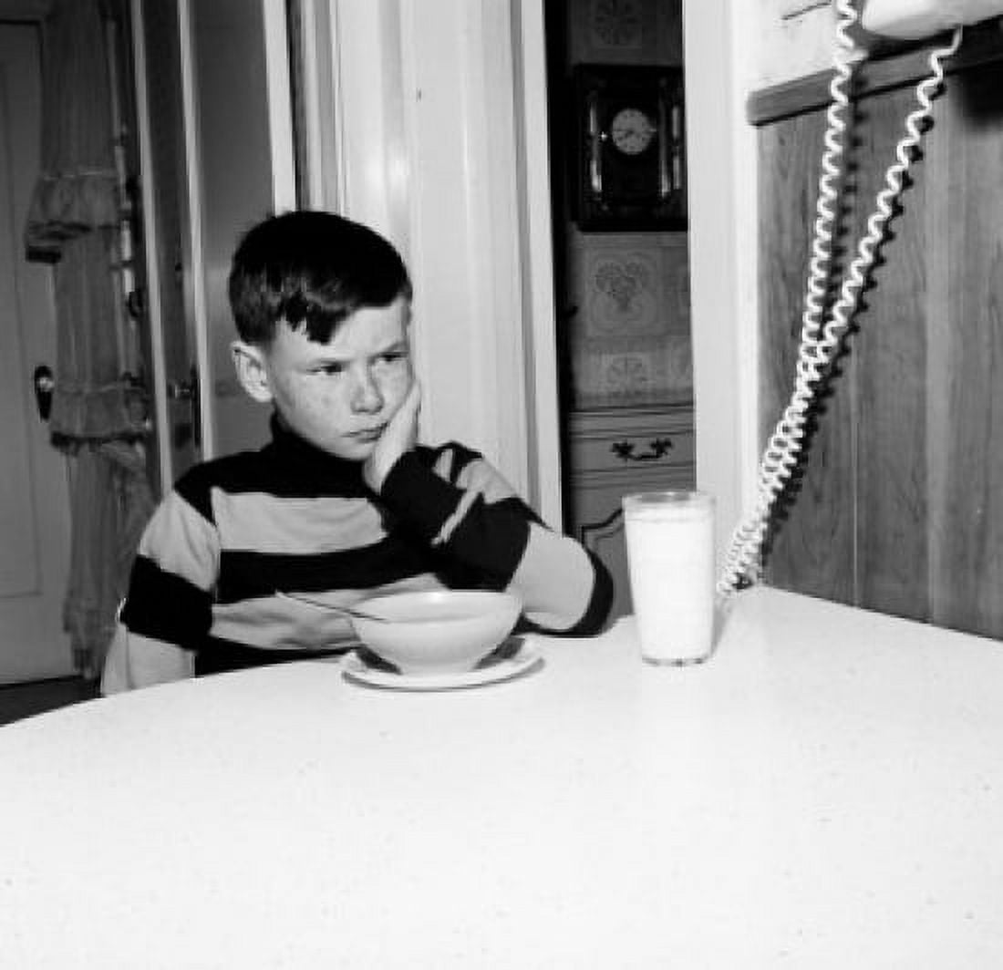 Boy frowning over bowl of cornflakes and glass of milk Canvas Art - (18 x 24)