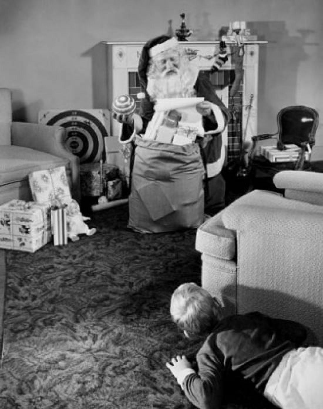 Boy hiding behind a couch and looking at Santa Claus Canvas Art - (18 x 24)