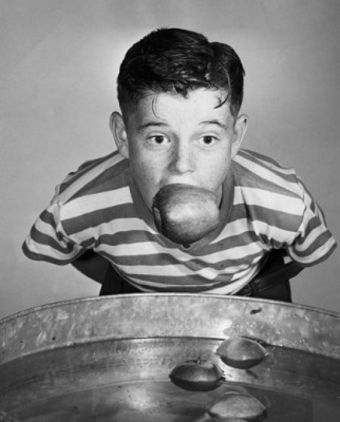 Boy holding an apple with his mouth Canvas Art - (18 x 24)