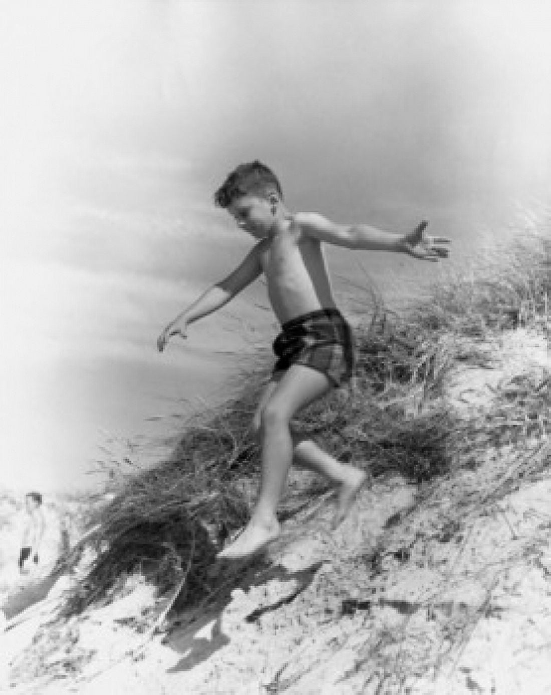 Boy jumping from sand dune Canvas Art - (24 x 36)