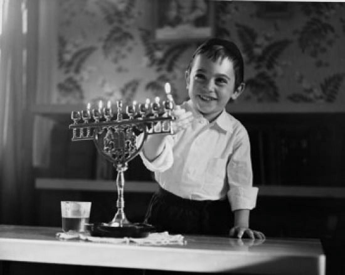 Boy lighting menorah candles and smiling Canvas Art - (24 x 36)