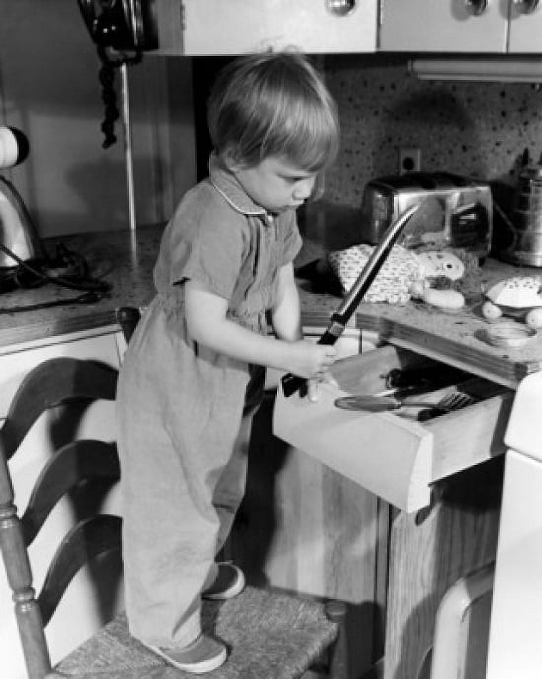 Boy looking at kitchen knife Canvas Art - (24 x 36)