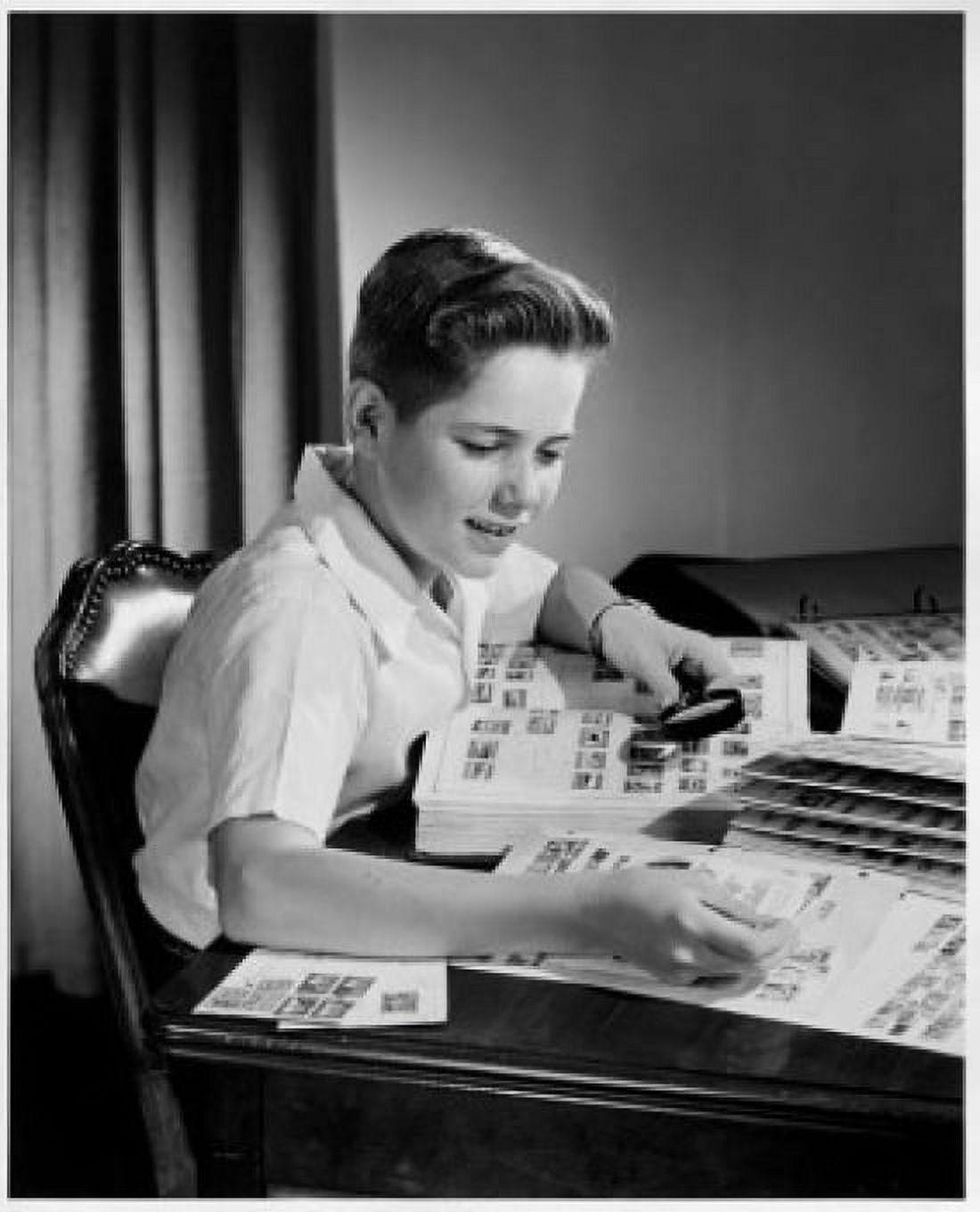 Boy looking at postage stamps through a magnifying glass Canvas Art - (24 x 36)
