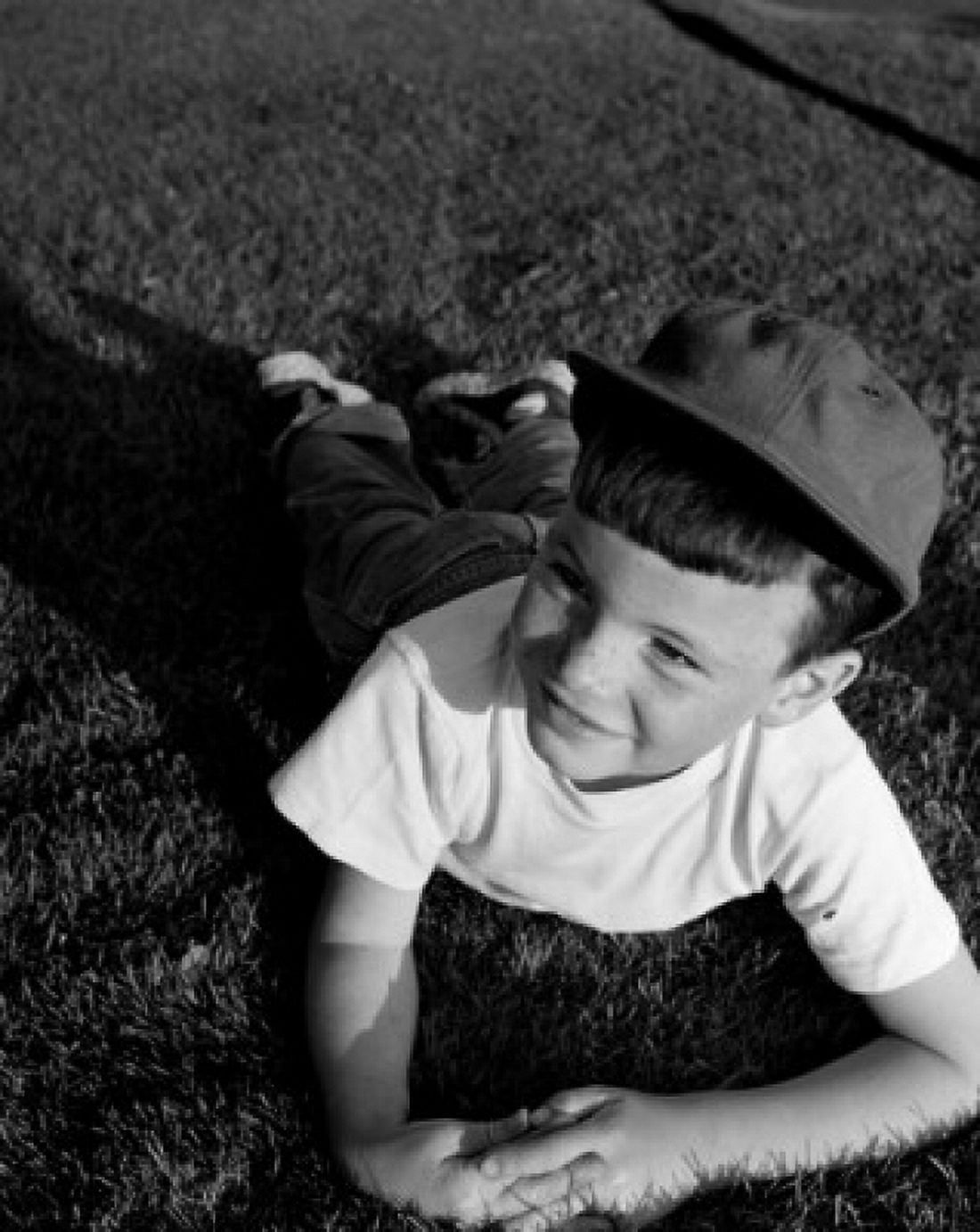 Boy lying on lawn Canvas Art - (24 x 36)