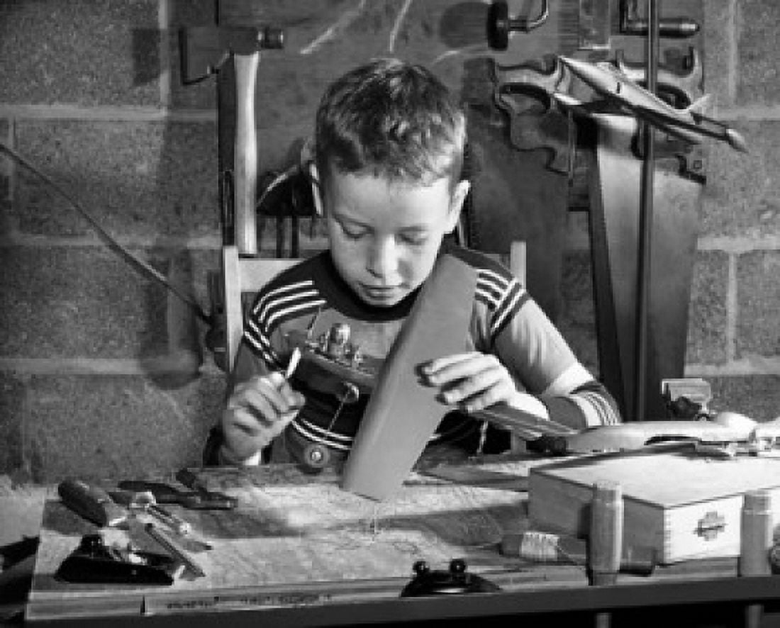 Boy making a model airplane Canvas Art - (18 x 24)