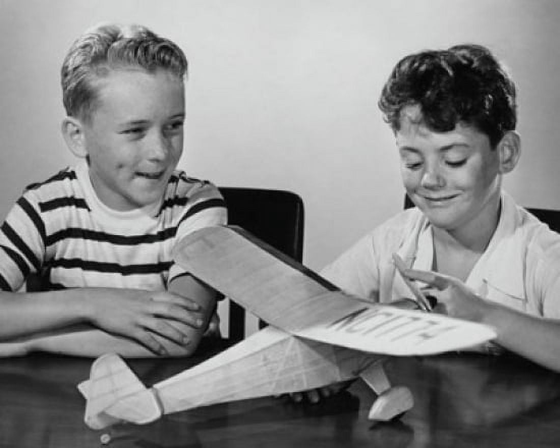 Boy making a model airplane and another boy sitting beside him Canvas Art - (18 x 24)
