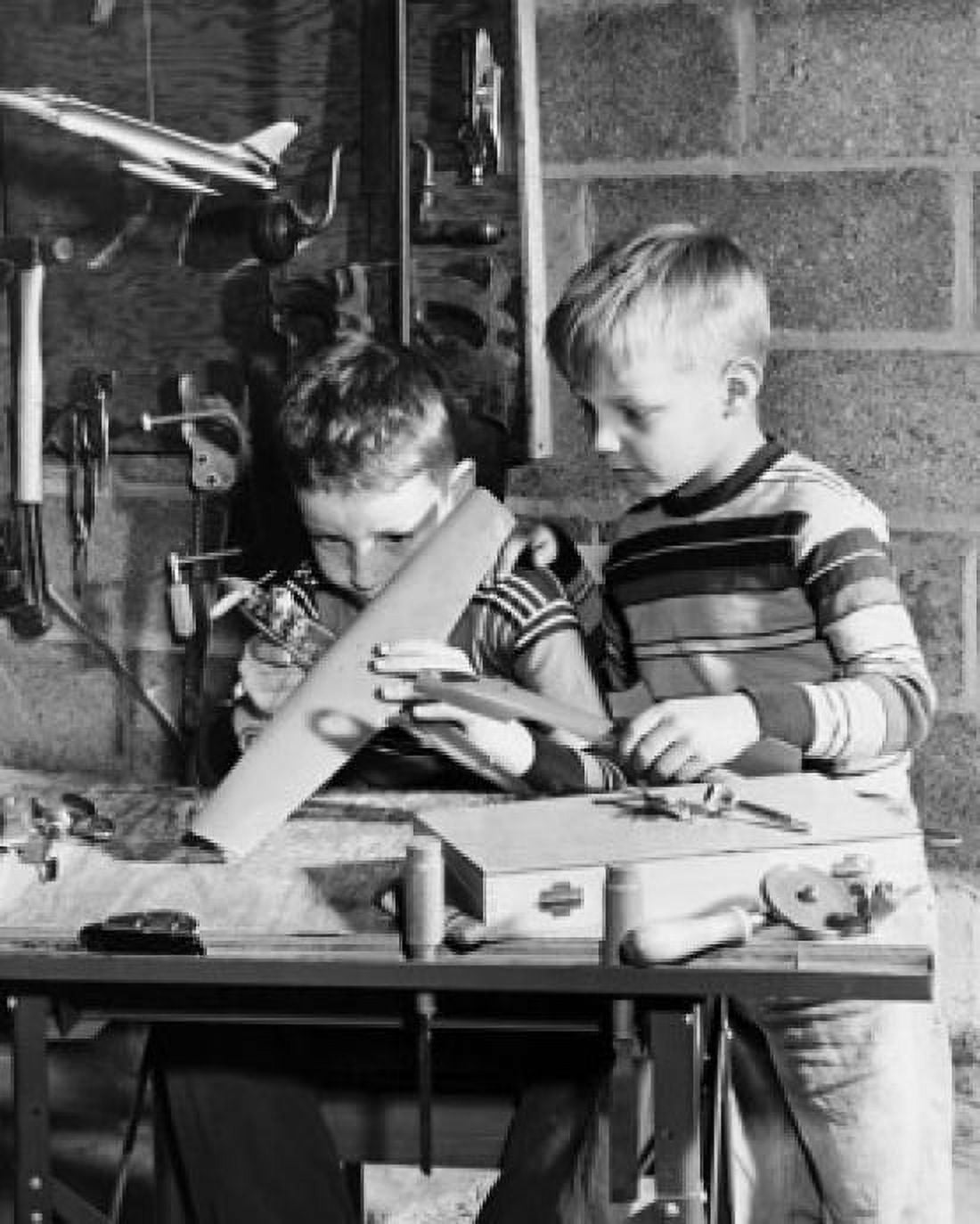 Boy making a model airplane with another boy looking at him Canvas Art - (24 x 36)