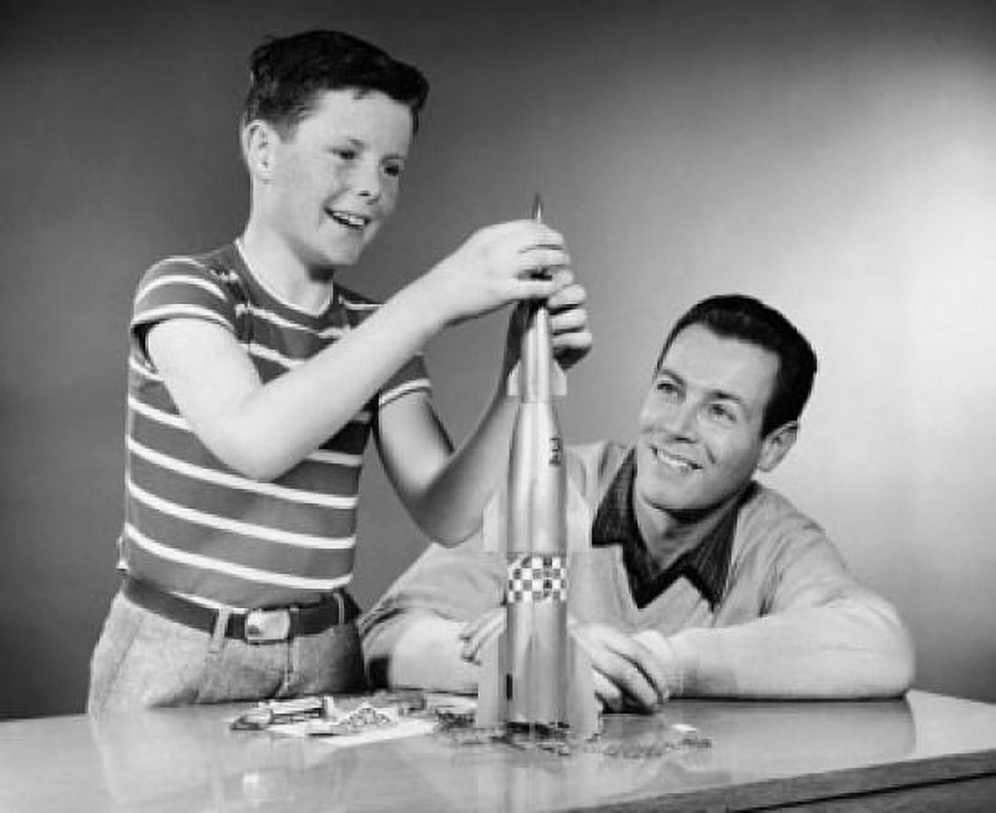 Boy making a model of a rocket and his father sitting beside him Canvas Art - (18 x 24)