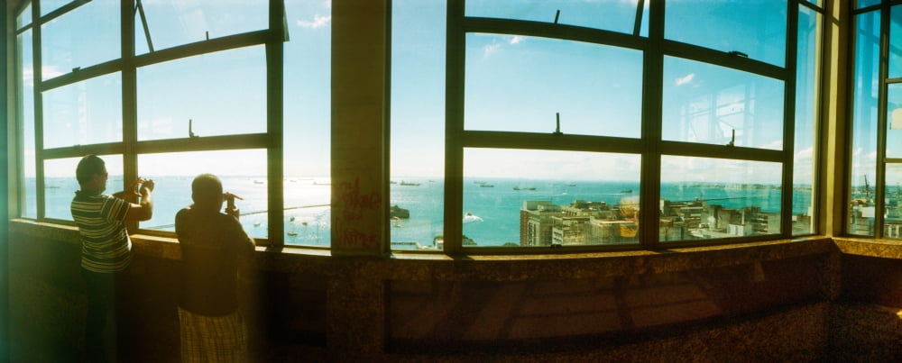 Boy and a man taking pictures of the Atlantic coast from inside the Lacerda Elevator Pelourinho Salvador Bahia Brazil Canvas Art - Panoramic Images (36 x 12)
