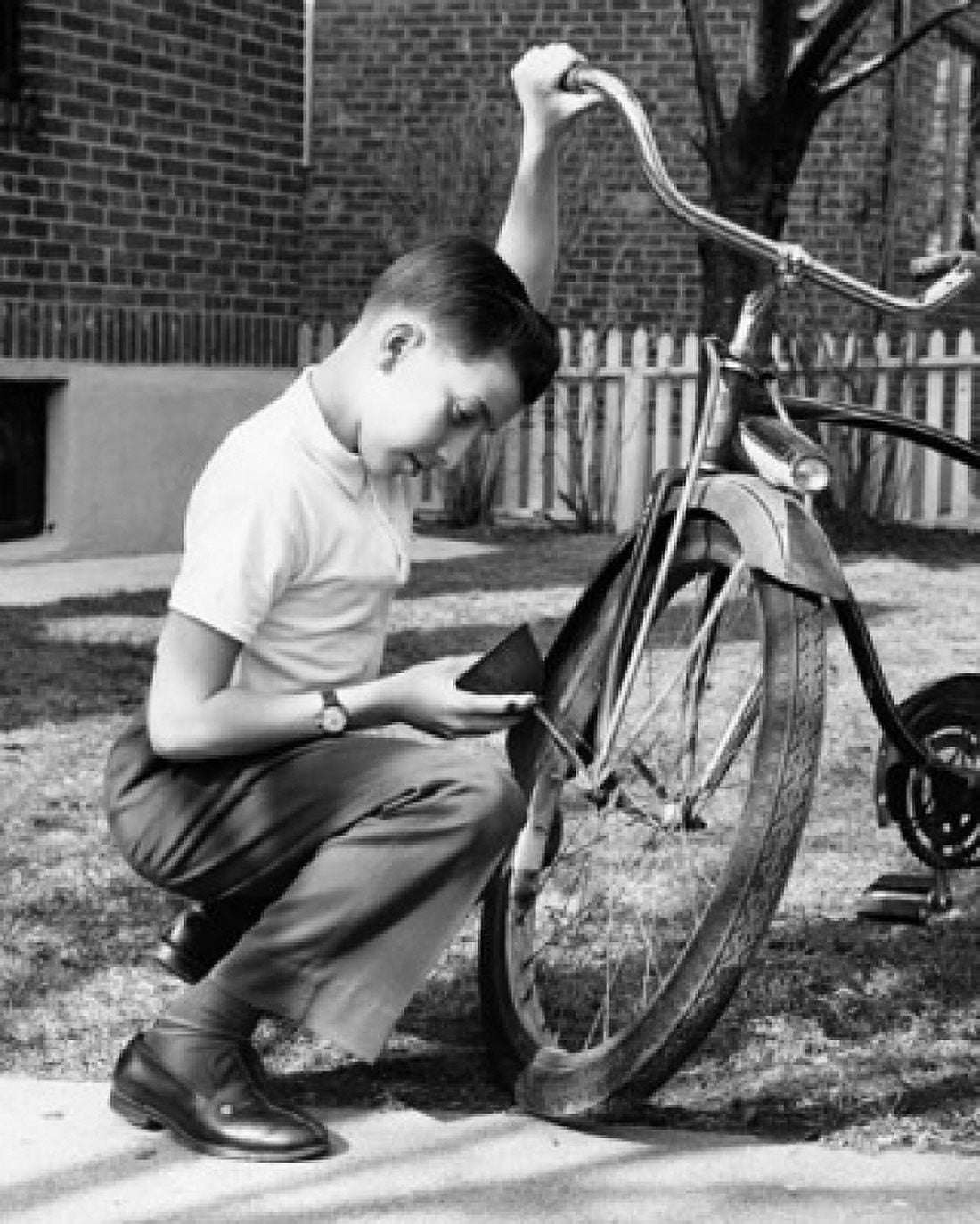 Boy oiling a bicycle Canvas Art - (24 x 36)