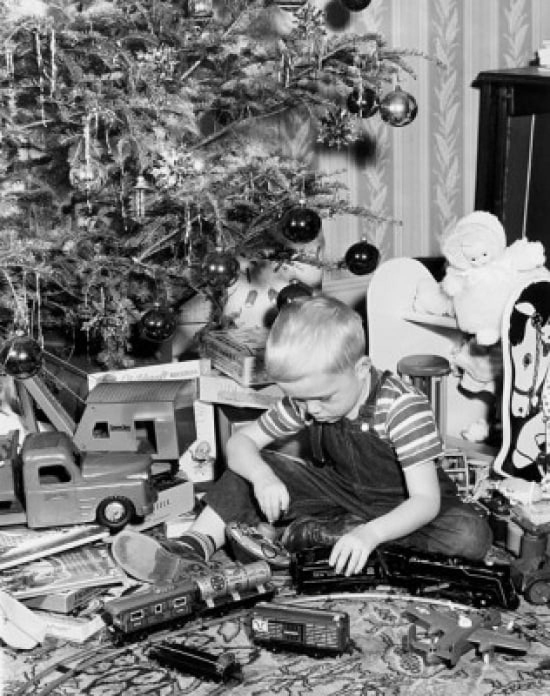 Boy playing with a toy train Canvas Art - (24 x 36)
