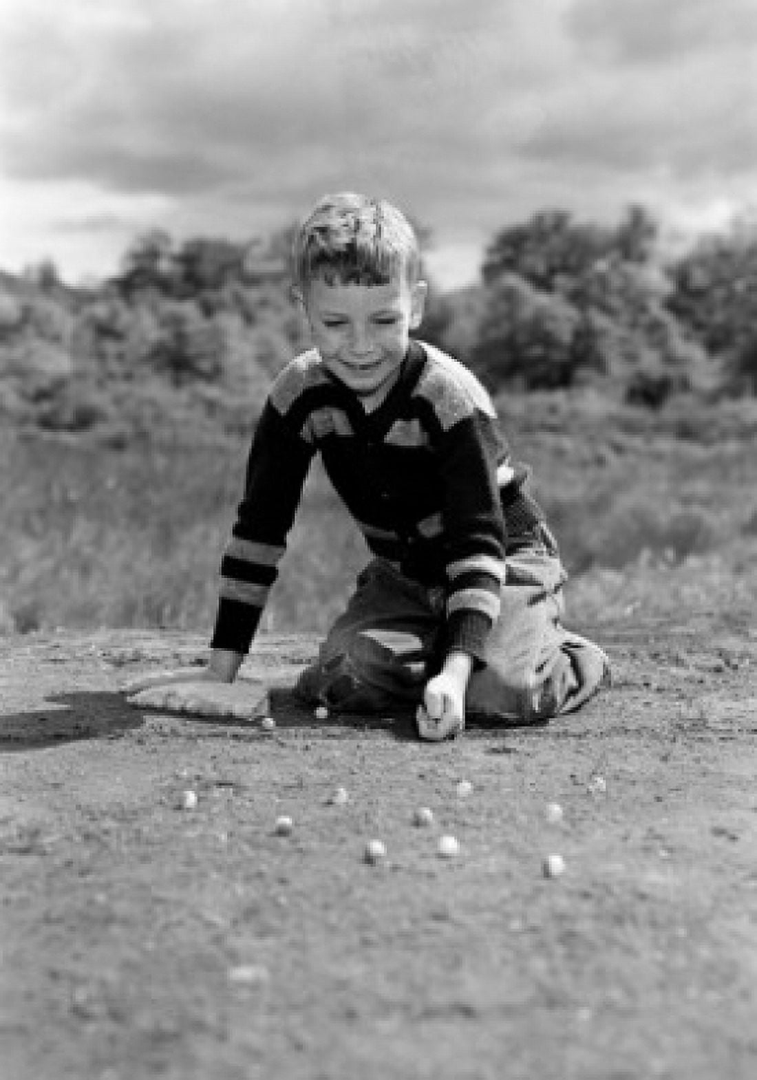 Boy playing with glass balls Canvas Art - (24 x 36)