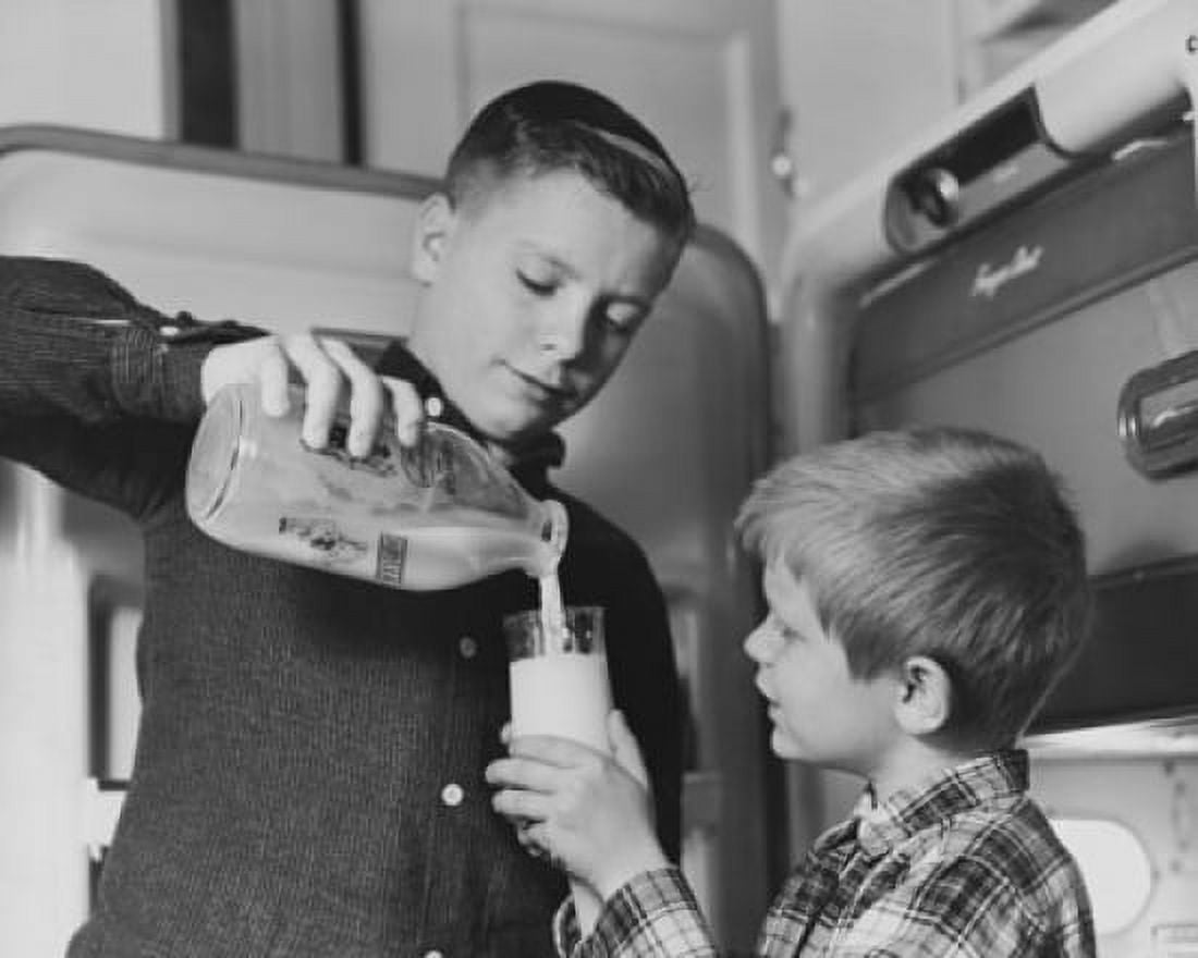 Boy pouring milk into a glass held by his brother Canvas Art - (18 x 24)