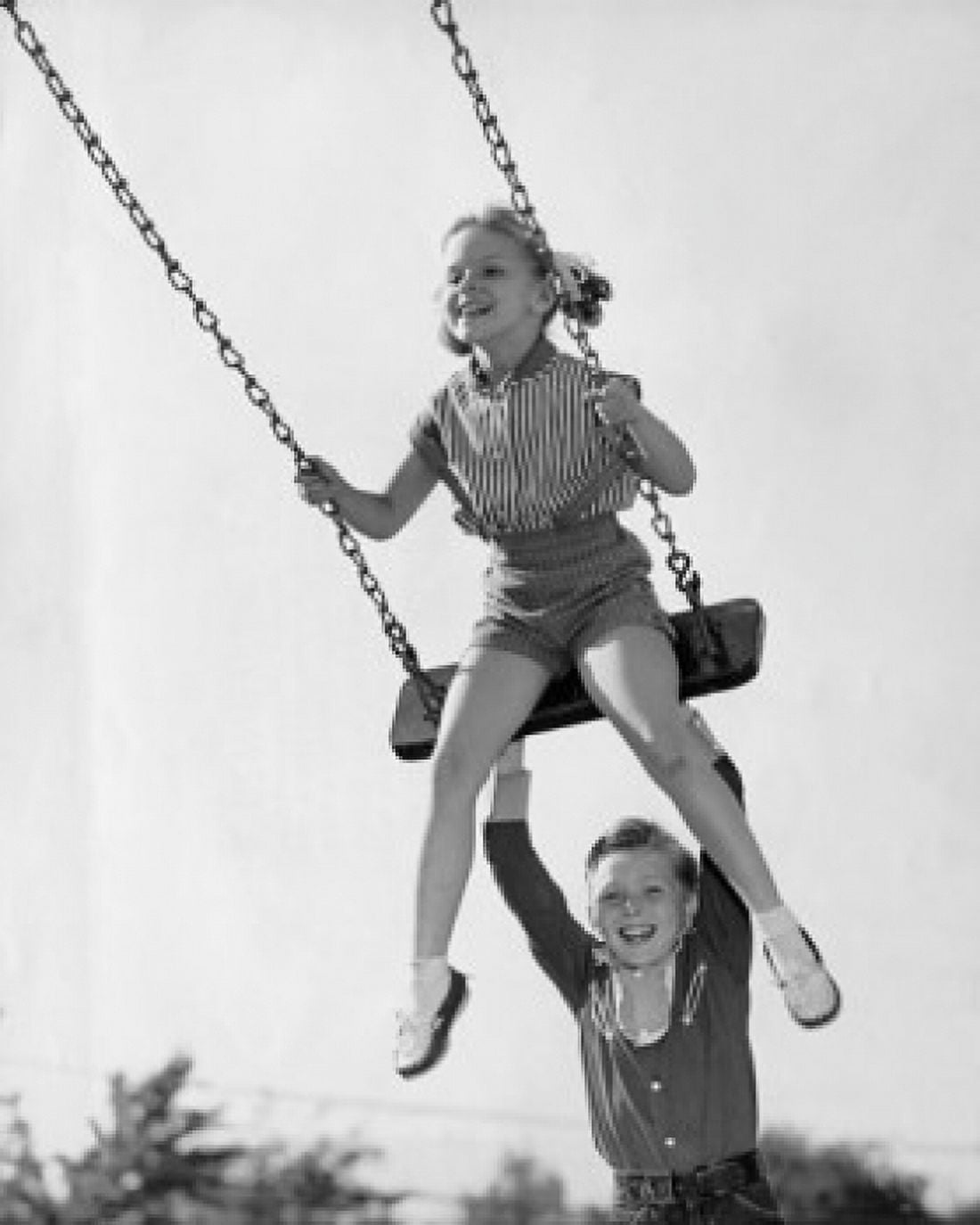 Boy pushing his sister on a swing Canvas Art - (18 x 24)