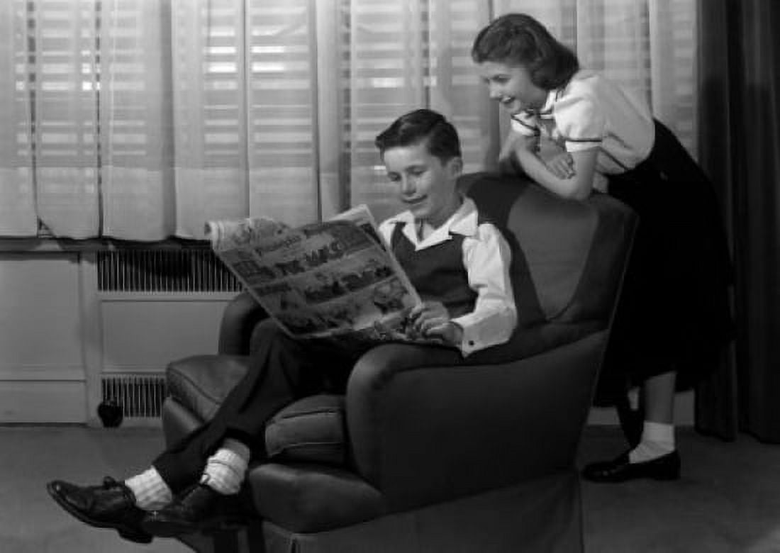 Boy reading comic in armchair with girl peeking over shoulder Canvas Art - (24 x 36)