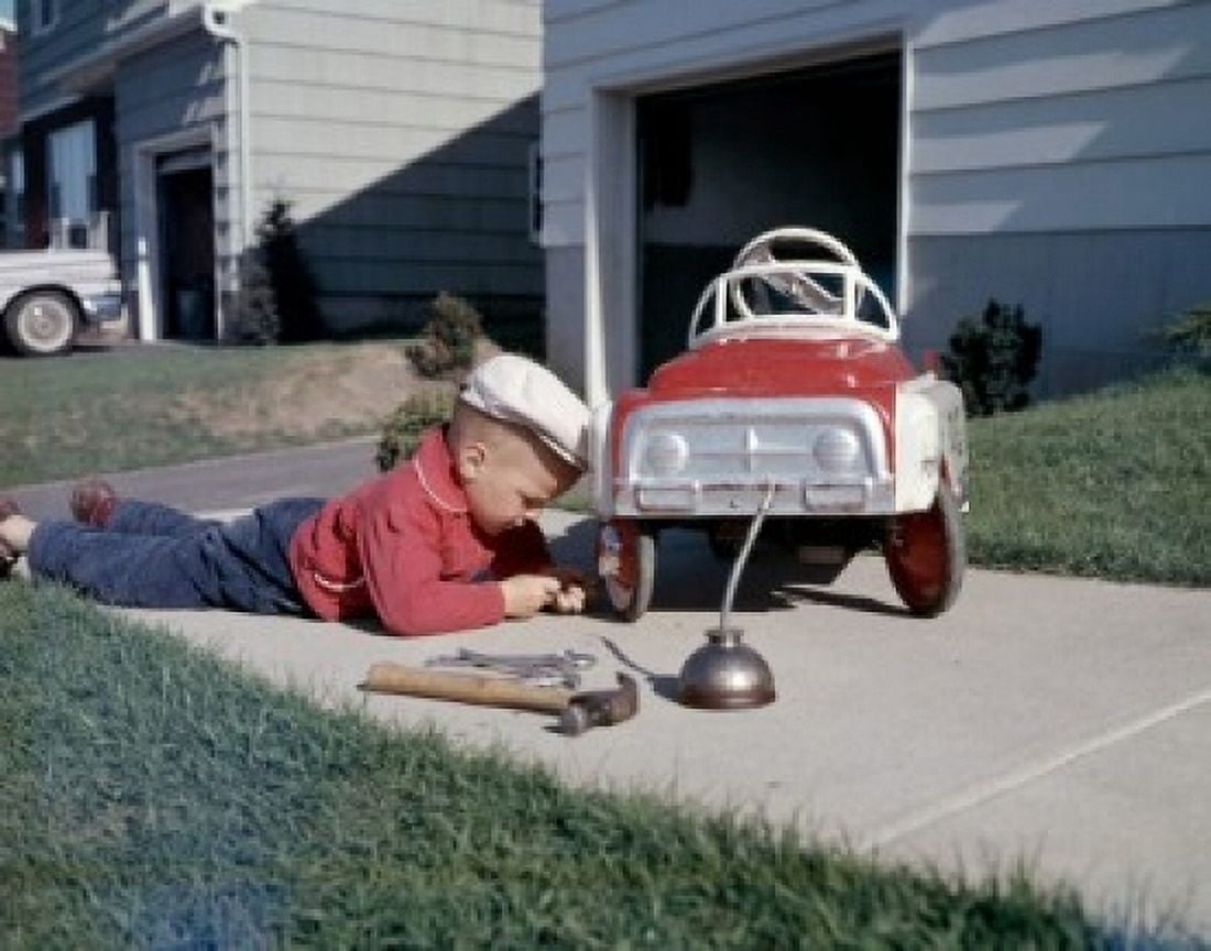 Boy repairing go-cart in yard Canvas Art - (24 x 36)