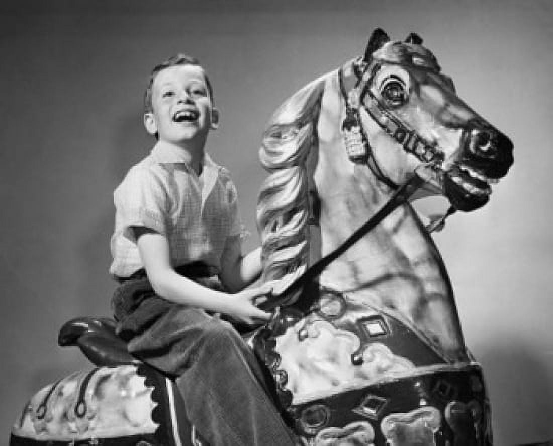 Boy riding on a carousel horse Canvas Art - (24 x 36)