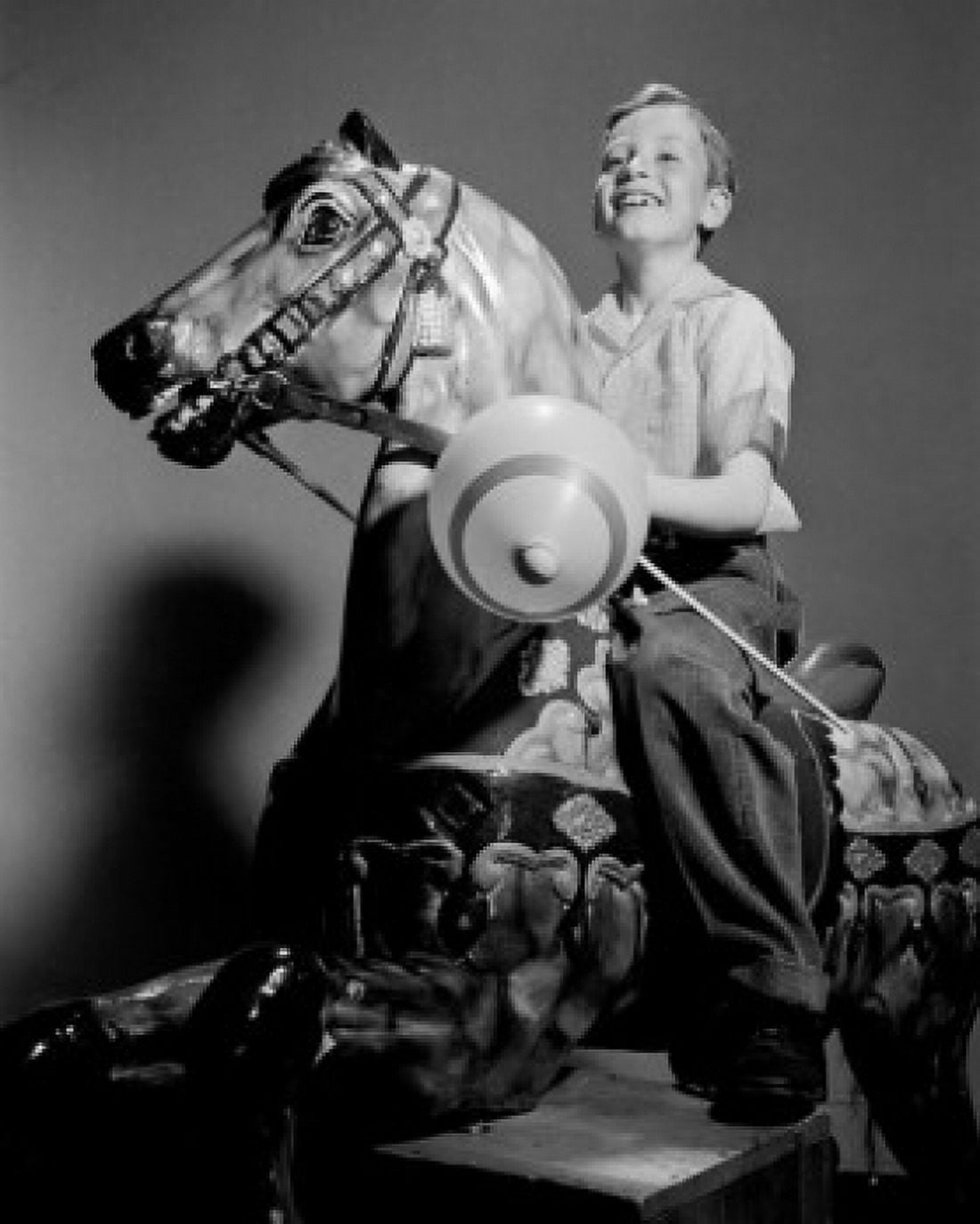 Boy riding on carousel Canvas Art - (24 x 36)