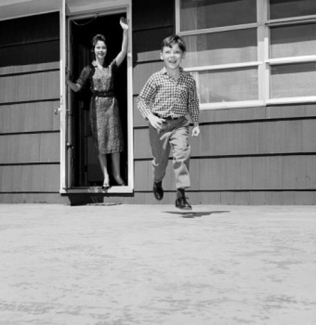 Boy running in backyard mother waving Canvas Art - (24 x 36)