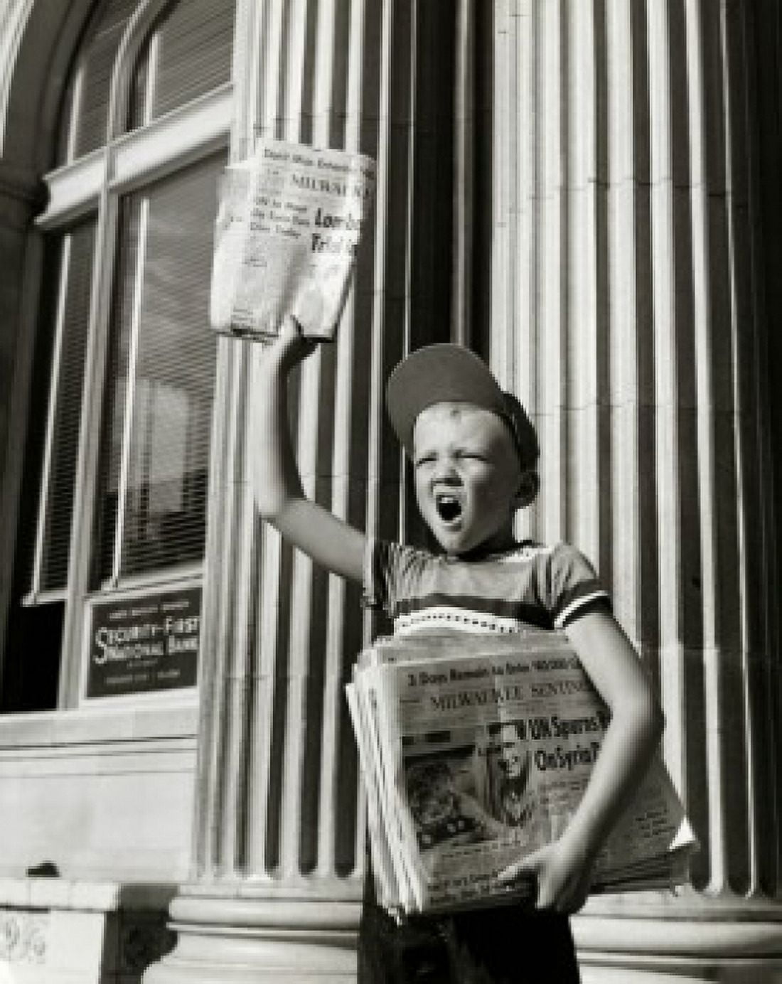 Boy selling newspapers in front of a building Canvas Art - (18 x 24)