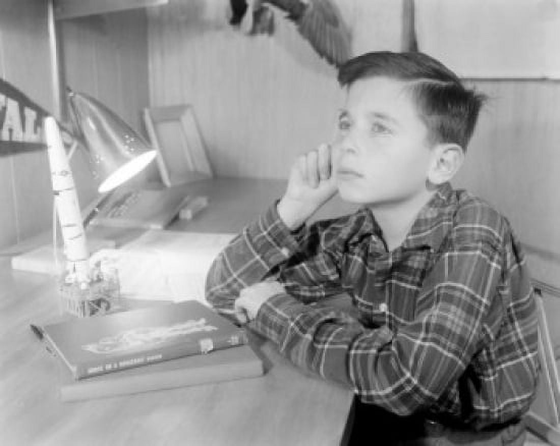 Boy sitting at desk with model missile Canvas Art - (18 x 24)