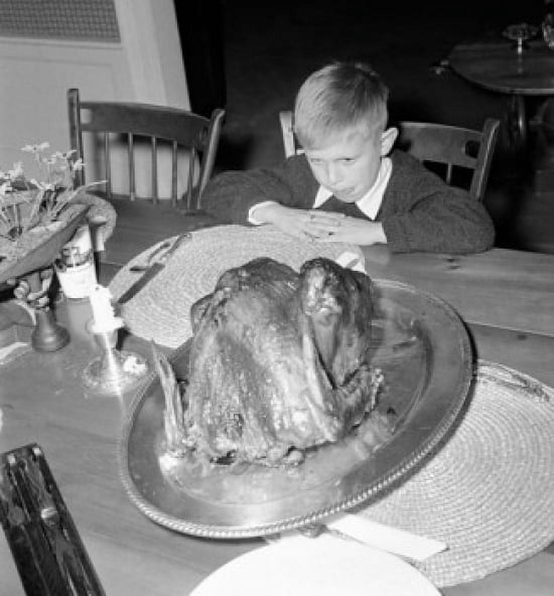 Boy sitting at dining table and looking at roasted turkey on Thanksgiving Day Canvas Art - (18 x 24)