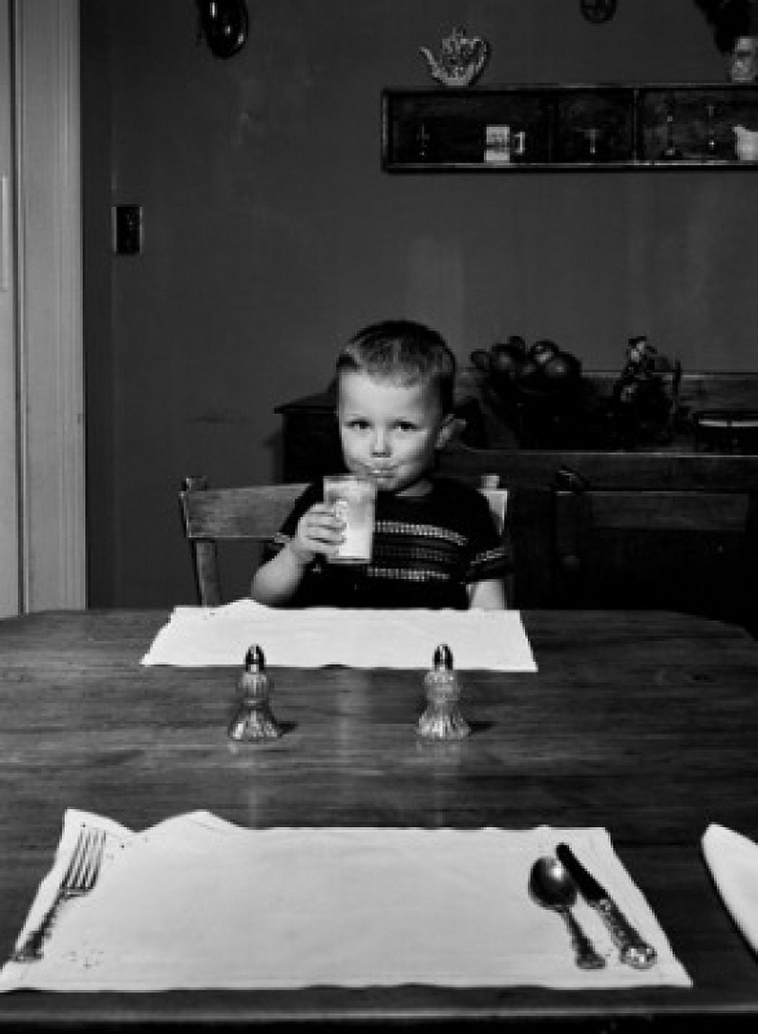 Boy sitting behind table drinking milk Canvas Art - (24 x 36)
