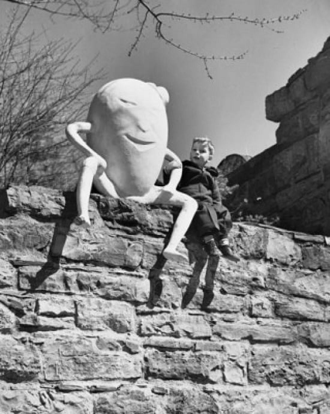 Boy sitting beside a sculpture of Humpty Dumpty Canvas Art - (18 x 24)
