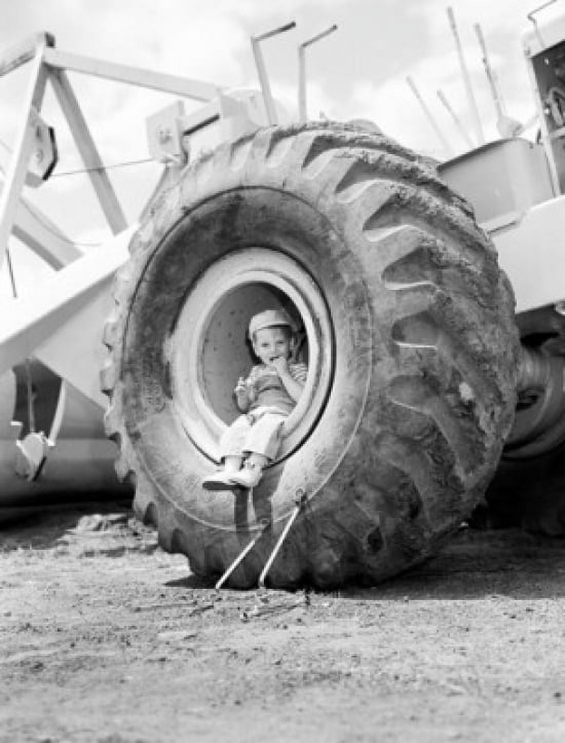 Boy sitting in vehicles tire Canvas Art - (24 x 36)