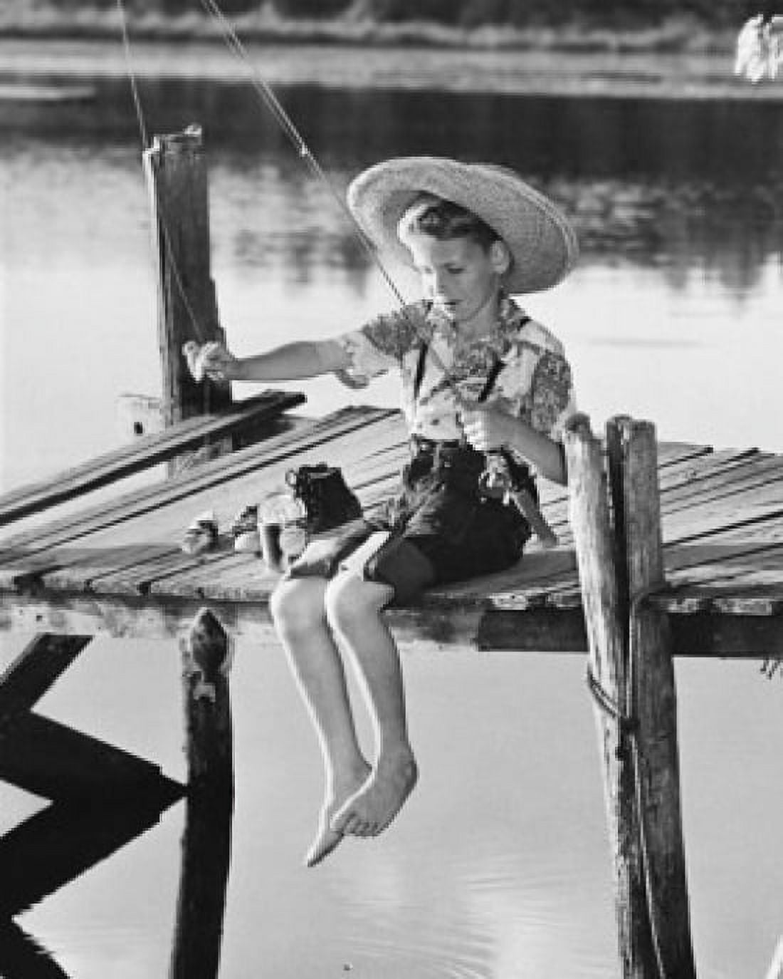 Boy sitting on a pier and fishing in a lake Canvas Art - (24 x 36)