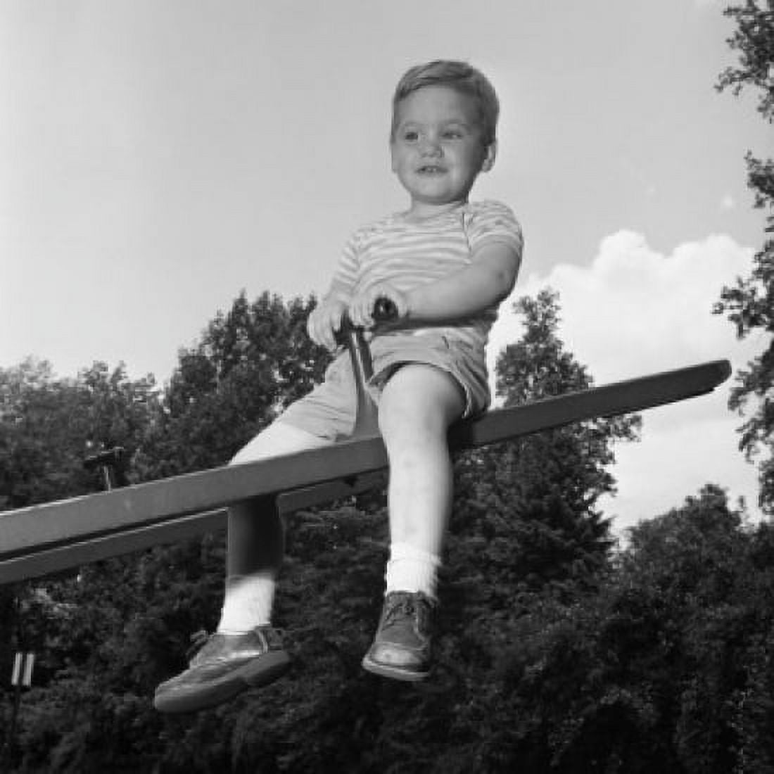 Boy sitting on seesaw and smiling Canvas Art - (24 x 36)