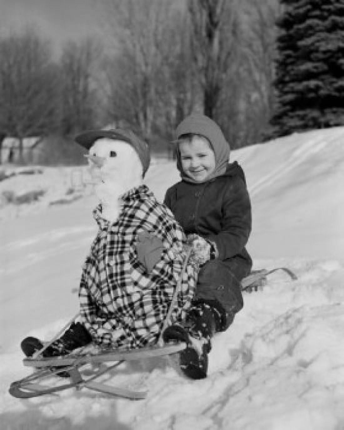 Boy sledding down snowy hill with snowman on sled Canvas Art - (24 x 36)