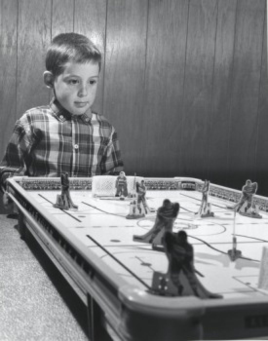 Boy standing near an ice hockey table Canvas Art - (24 x 36)