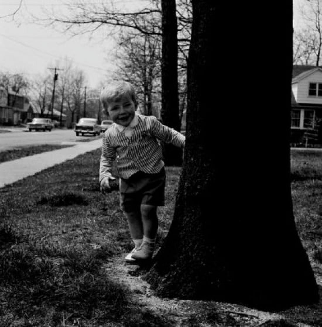 Boy standing near tree trunk and looking at camera Canvas Art - (18 x 24)