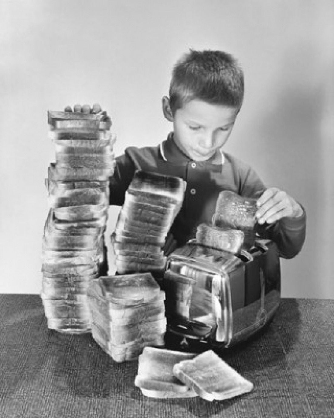 Boy toasting bread in a toaster Canvas Art - (18 x 24)