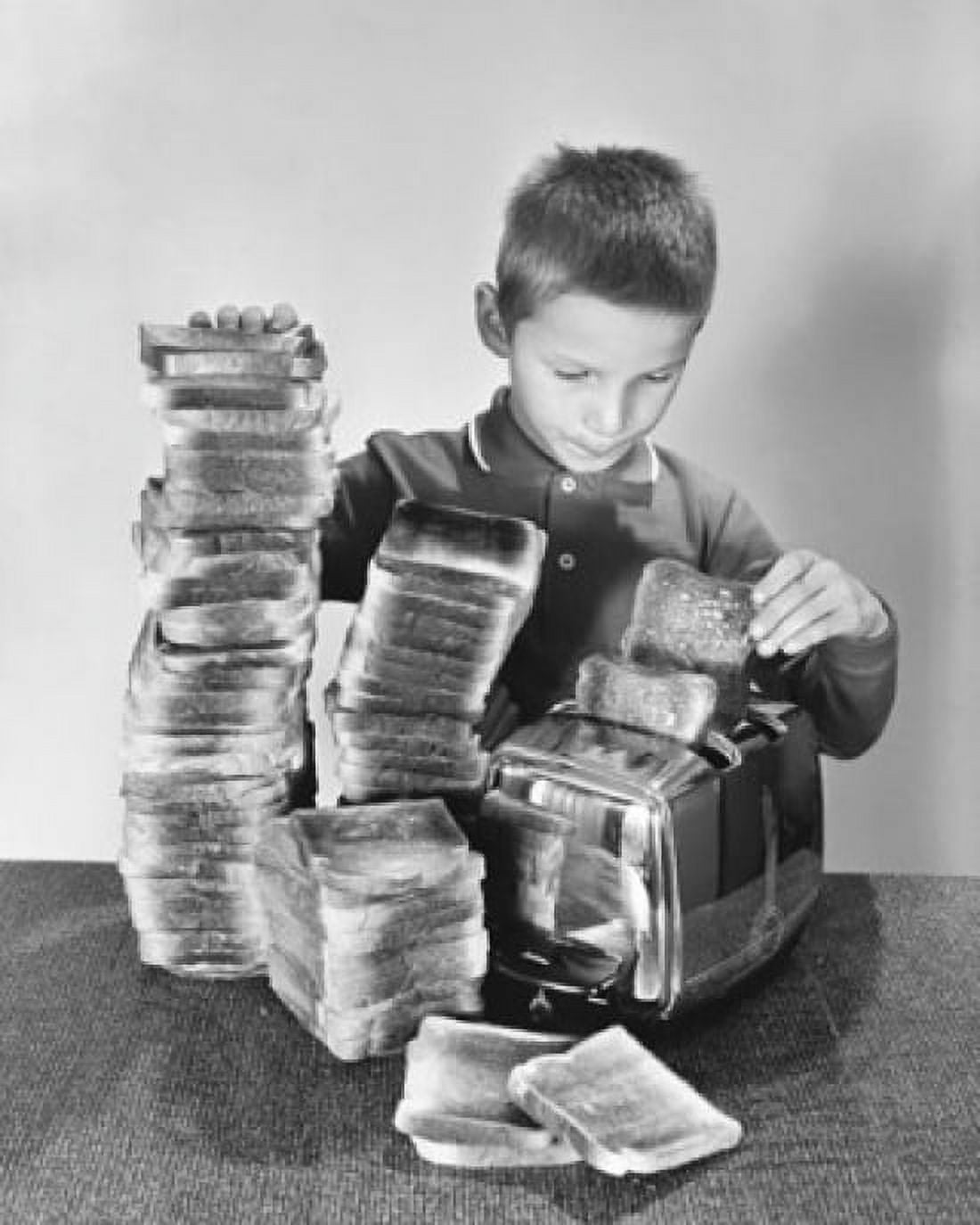 Boy toasting bread in a toaster Canvas Art - (24 x 36)