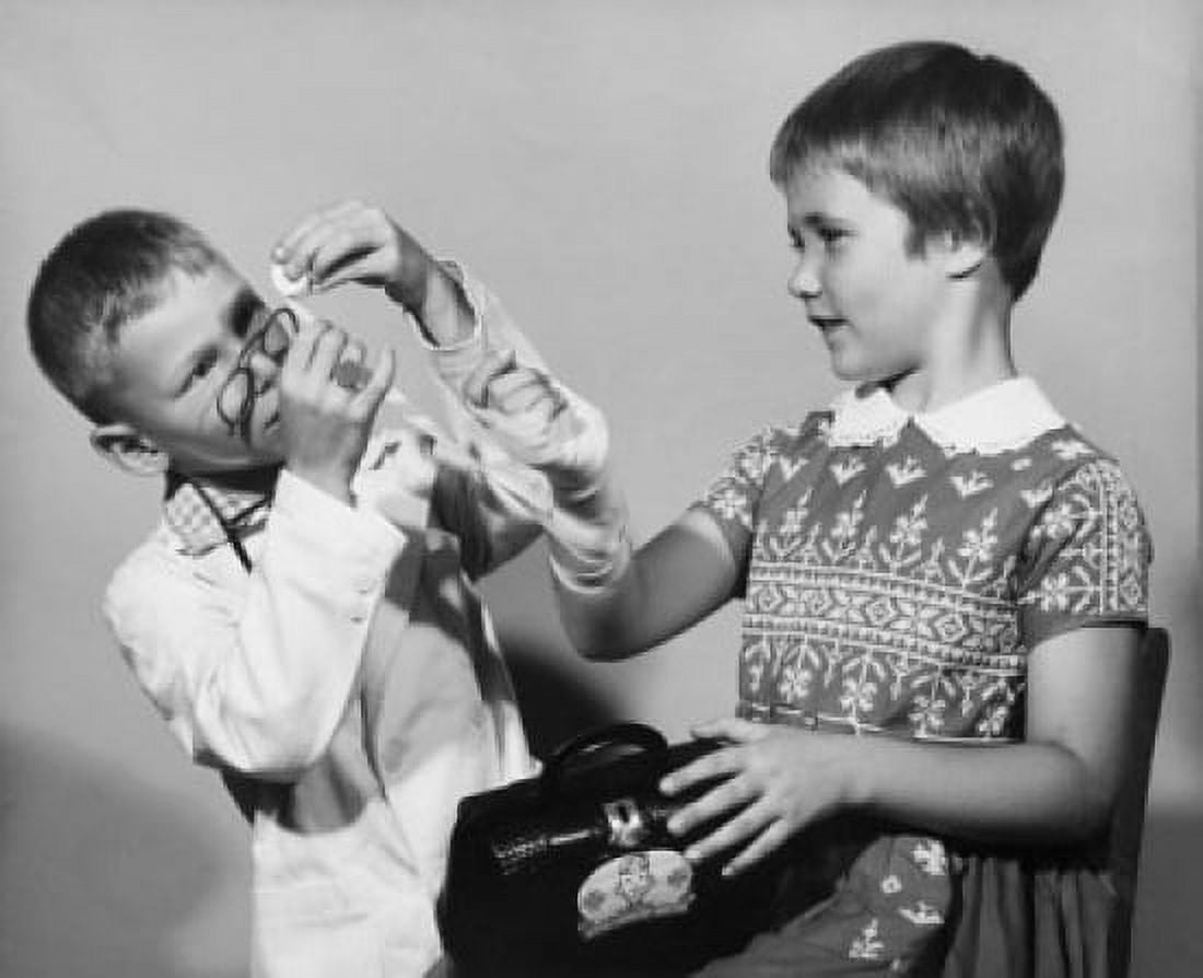 Boy tying a bandage on a girls hand Canvas Art - (18 x 24)