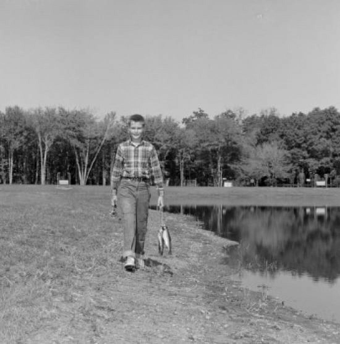 Boy walking along pond and carrying fish Canvas Art - (18 x 24)