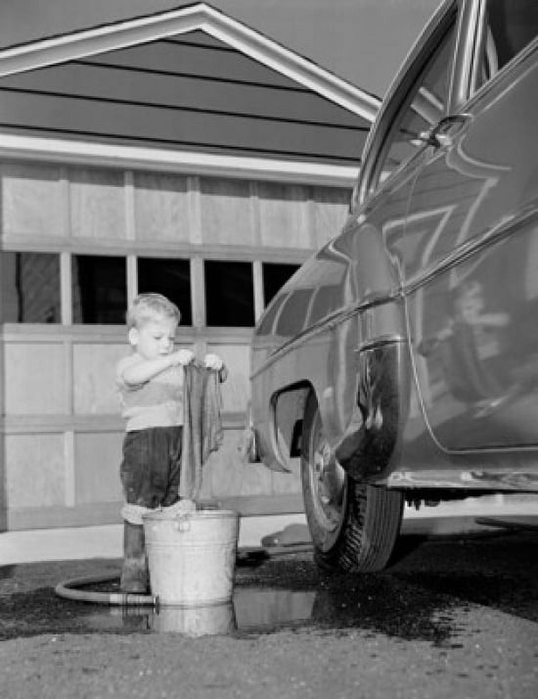 Boy washing car in front of house Canvas Art - (18 x 24)