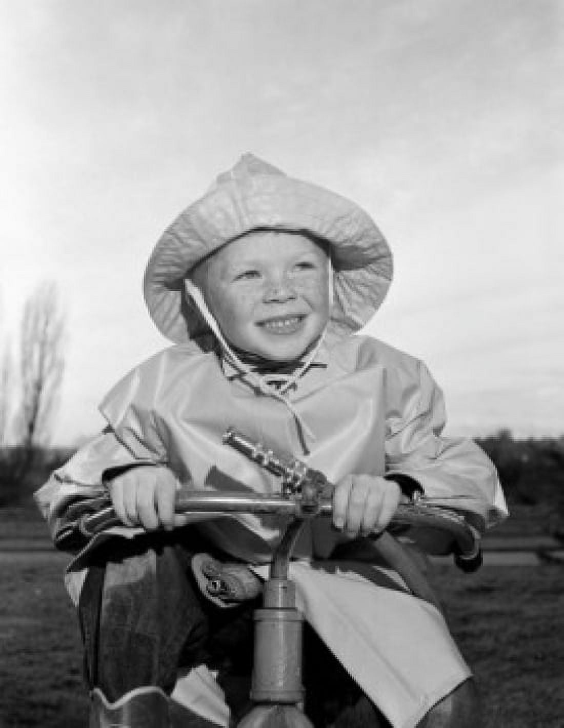 Boy wearing rain coat and holding garden hose Canvas Art - (18 x 24)
