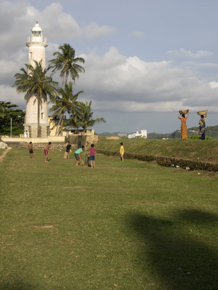 Boys playing cricket Galle Lighthouse and rampart around Galle Fort Galle Southern Province Sri Lanka Canvas Art - Panoramic Images (12 x 16)