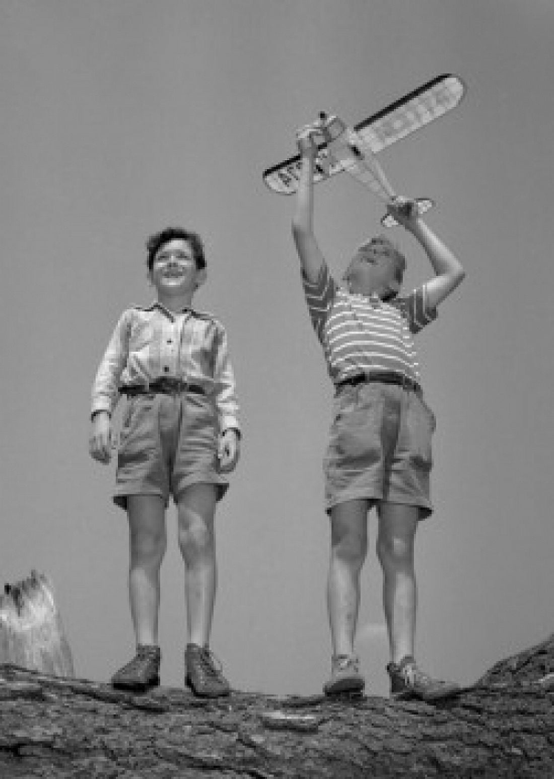 Boys playing with model airplane Canvas Art - (24 x 36)