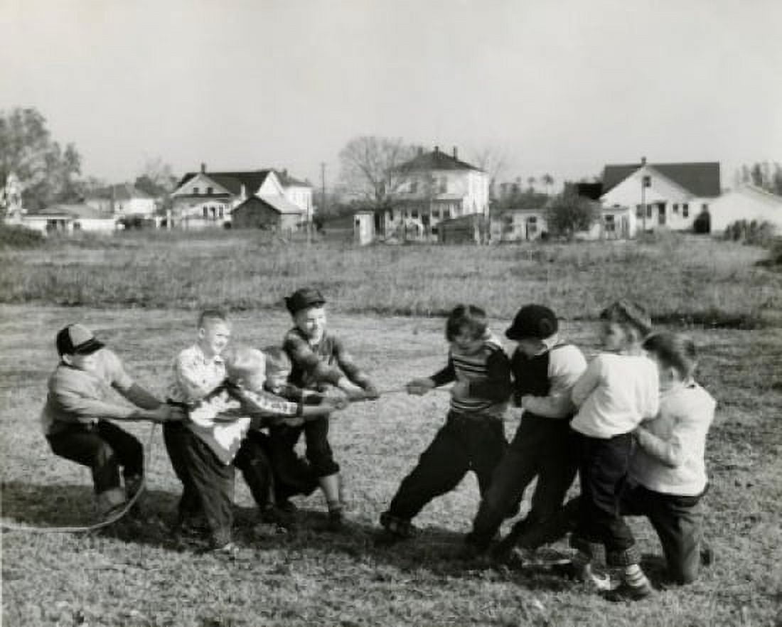 Boys pulling rope on field Canvas Art - (18 x 24)