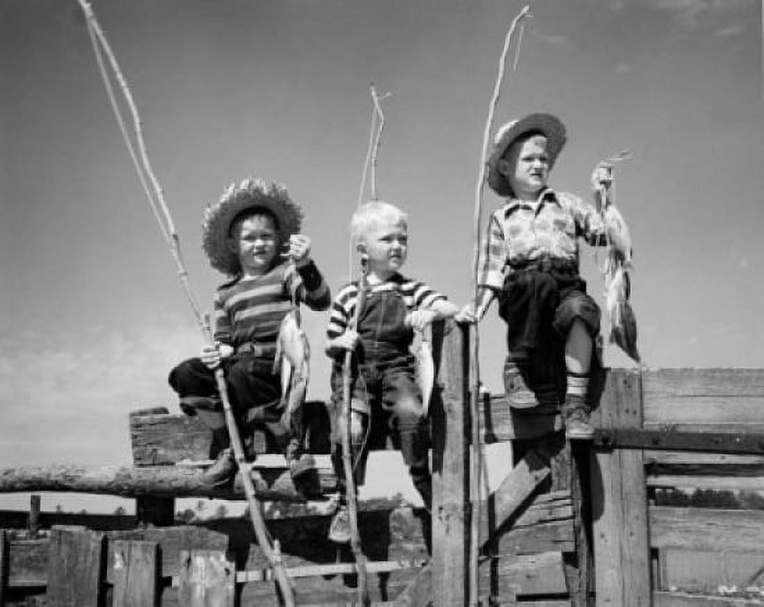 Boys sitting on fence holding fishing rods and fish Canvas Art - (18 x 24)