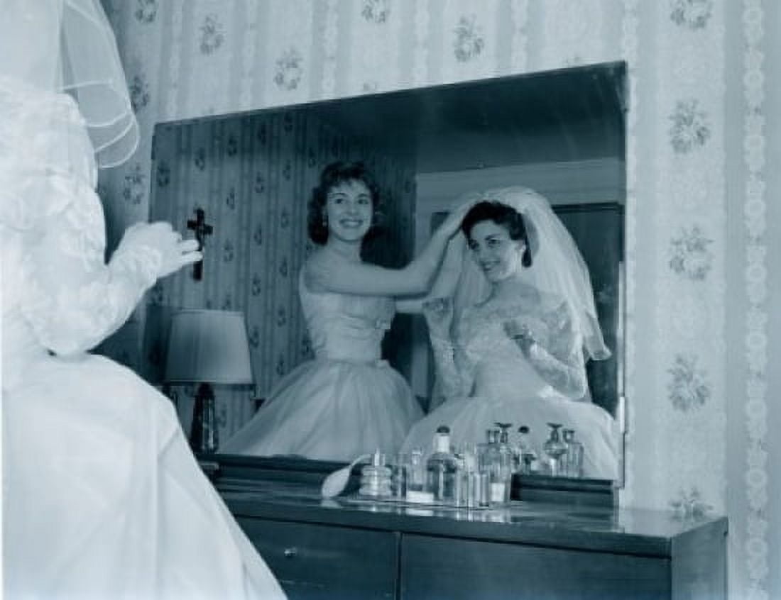Bridesmaid attaching veil to brides hair in front of mirror Canvas Art - (18 x 24)