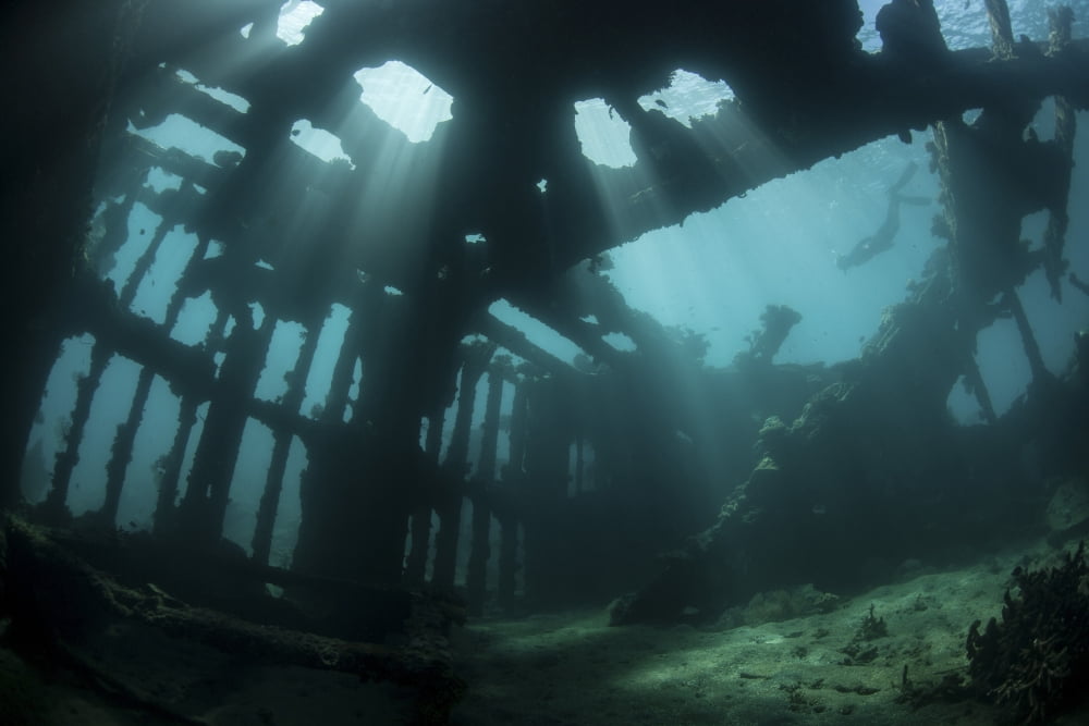 Bright sunlight pierces a shallow World War II shipwreck Canvas Art - Ethan DanielsStocktrek Images (17 x 12)