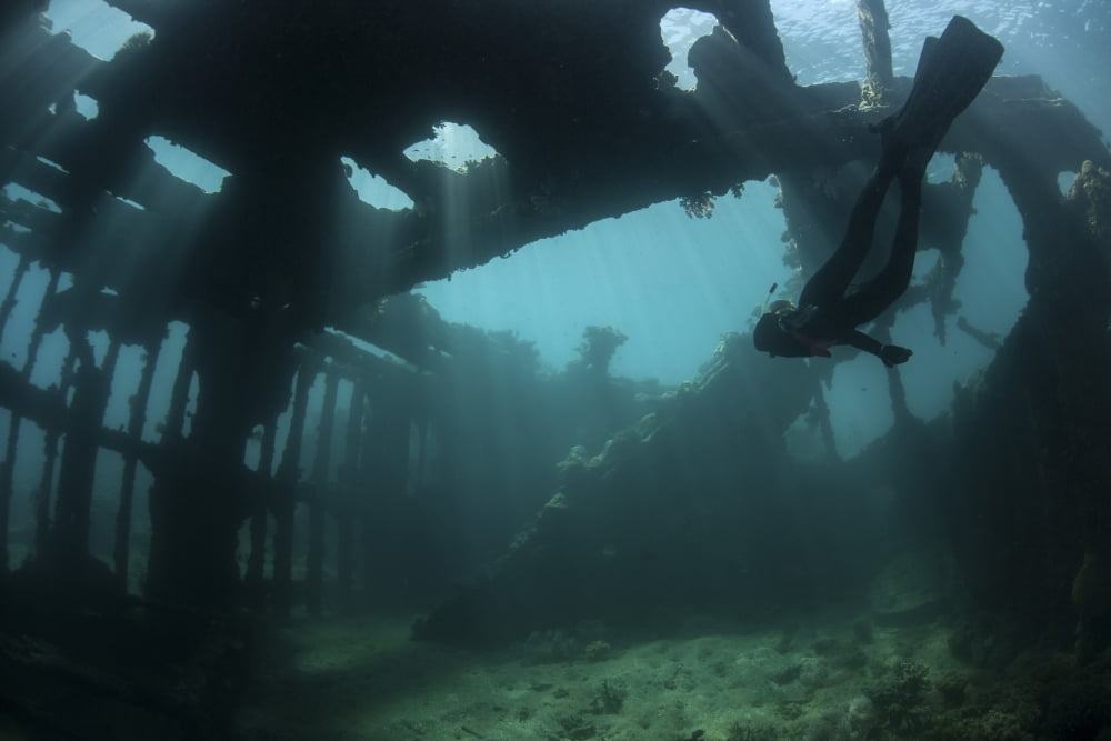 Bright sunlight pierces a shallow World War II shipwreck Canvas Art - Ethan DanielsStocktrek Images (34 x 23)