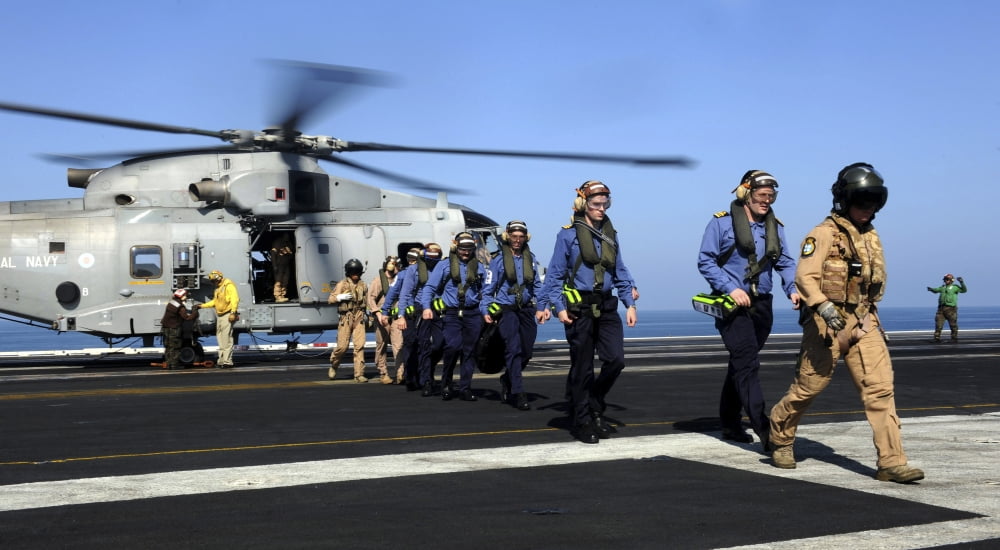 British Sailors are escorted off an EH-101 Merlin helicopter aboard USS John C Stennis Canvas Art - Stocktrek Images (39 x 21)